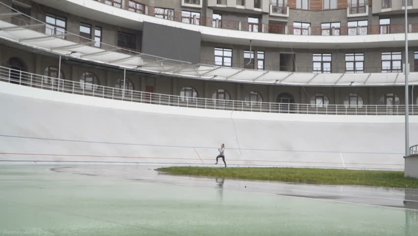 Female athlete sprinting on a turn of run path running athletic track. 120fps