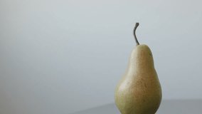 Organic fruit from genus Pyrus close-up 4K 2160p UltraHD tilting footage - Pear with peduncle on the table slow tilt 3840X2160 UHD video