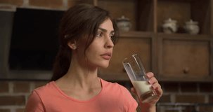 Woman drinking milk on glass at home kitchen 4k video. Dairy healthy food
