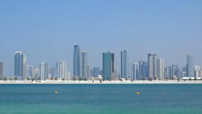 Highrise architecture towers over the sea beachline and dominates the Dubai skyline on a typical. sunny day. FullHD video 1080p