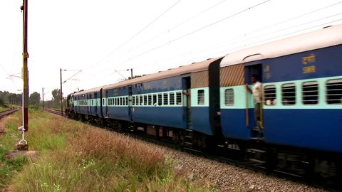 Indian passenger train passes by suburbs of Bangalore, Karnataka, India.