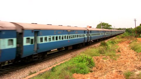 Indian passenger train passes by suburbs of Bangalore, Karnataka, India.