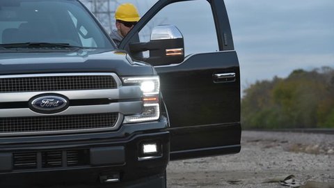 November 1st, 2017. Joliet, Illinois, United States of America. Caucasian Construction Worker Making Field Research While Staying Near His Company 2017 Model Year Ford F-150 Pickup Truck