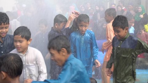 SHAH ALAM, MALAYSIA - 2 December 2017 : Children play in water sprayed from a fire hydrant during the mass circumcision ceremony in Shah Alam, Selangor.