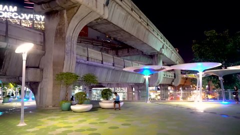 Central walkway from Siam to MBK in Bangkok at night with two story skytrain bridges - Bangkok, Thailand - October 2017