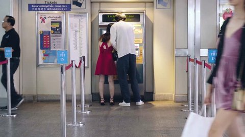 Couple buying ticket at BTS Skytrain ticket machine - Bangkok, Thailand - September 2017