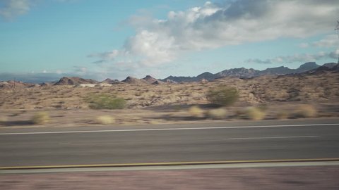 Driving plate side view moving through desert in car