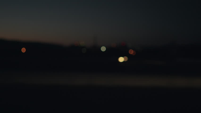 Blurred driving plate side view moving through hills and fields in night