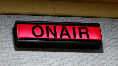  ON AIR sign being turned on and off on wall of studio
