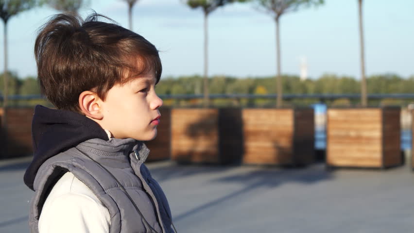 The schoolboy looks through binoculars