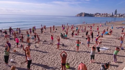 Benidorm, Spain - December 1st 2017: A lot of pensioners do sport exercises on the beach near by blue sea.
