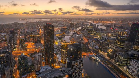 Rolling Clouds, sun rays burst through the clouds during sunrise. 4k time lapse of Melbourne city skyline, view from high level building. Pan right
