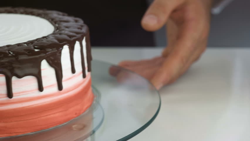 Close up of professional Chef squeezes cream and makes cake base