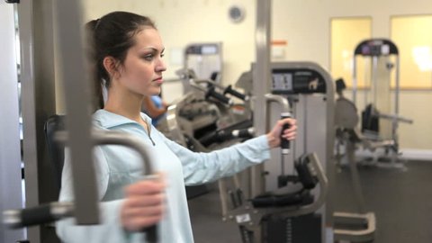 Pretty girl working out in fitness center. Young woman on exercise bike in gym. Athlete working out to stay healthy and fit. 