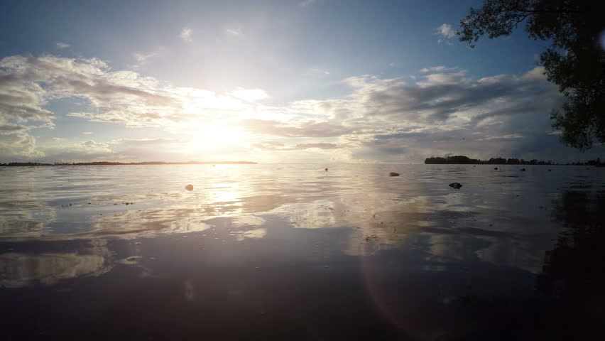 Calm and beautiful nature scene with sunset over lake in Sweden. Peaceful and idyllic summer landscape.