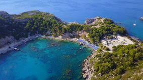 Aerial bird's eye view video taken by drone of famous beach of Anthony Quinn with clear water rocky seascape, Rodos island, Greece
