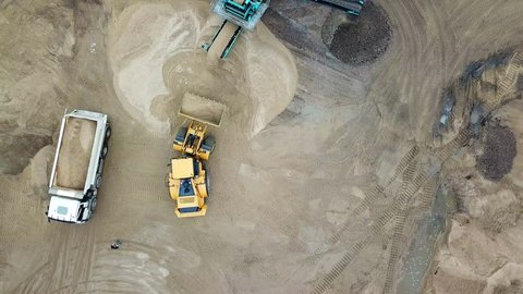 Sand mining industry. Bulldozer machine. Crawler bulldozer moving at sand mine. Mining machinery working at sand quarry. Drone view of mining equipment at industrial sand quarry. Earth mover