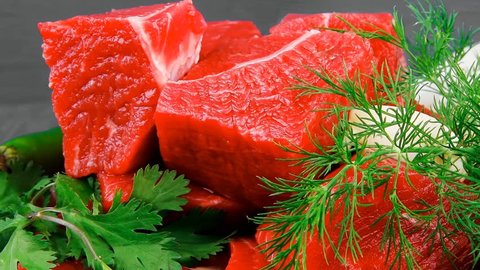 raw fresh beef meat slices in a white bowls with dill and green hot peppers serving over blue wooden table hidef intro slow motion