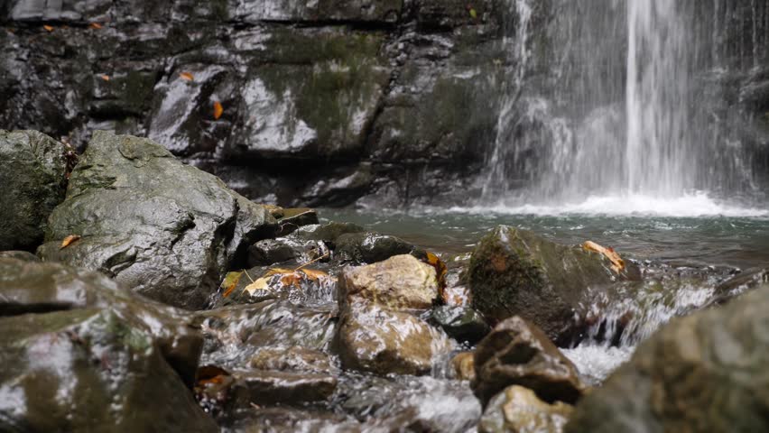 4k, slow motion. tourist bowler on a burner at the foot of the mountain, against a waterfall