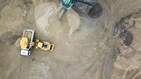 Aerial view loading bulldozer in open air quarry. Sand mining industry. Bulldozer machine. Crawler bulldozer moving at sand mine. Mining machinery working at sand quarry. Drone view of mining 