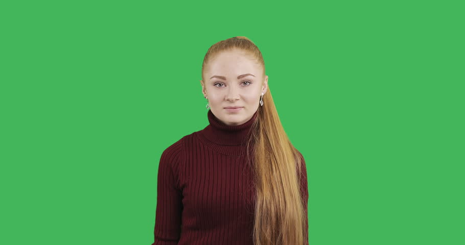 Female caucasian model with a long red hair is very surprised. Young woman with a great impression on green chroma key background.