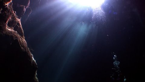 Caves of Yucatan cenotes underwater in Mexico. Scuba diving in clean and clear underground water in reflection of sunlight.