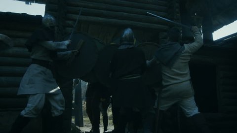 Medieval Battle. Viking Warriors Break into Wooden Fortress Yard and Fight with Slavs Guards. Violent Fight with Swords, Axes and Shields. Slow Motion. Medieval Reenactment. Shot on RED EPIC-W 8K.