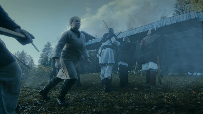 Large-Scale Medieval Battle Reenactment. Violent Tribe of Warriors Attack Wooden Fortress Wall, They Climb Ladders, Guards Try to Defend Fortification.They Fight with Axes, Swords, Spears, Bows.