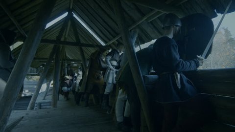 Large-Scale Medieval Battle Reenactment. Guards on the Wall of the Wooden Fortress Get Ready to Repulse Attack. They Fight with Axes, Swords, Spears. Shot on RED EPIC-W 8K Helium Cinema Camera.