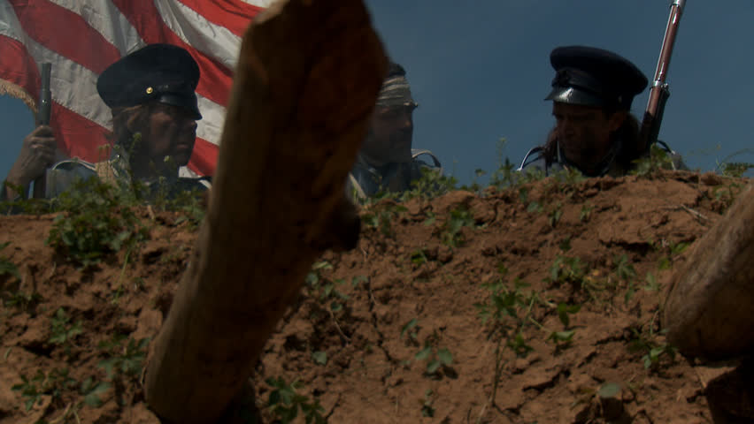 MEXICO - SUMMER 2017 - Mexican-American War anniversary reenactment -- before battle.  Several American Soldiers stand atop earthen fortress, with American flag and muskets in hot summer mexican sun.