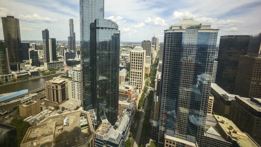 Rolling Clouds during bright day light sky. 4k time lapse of Melbourne city skyline, view from high level building. Tilt up