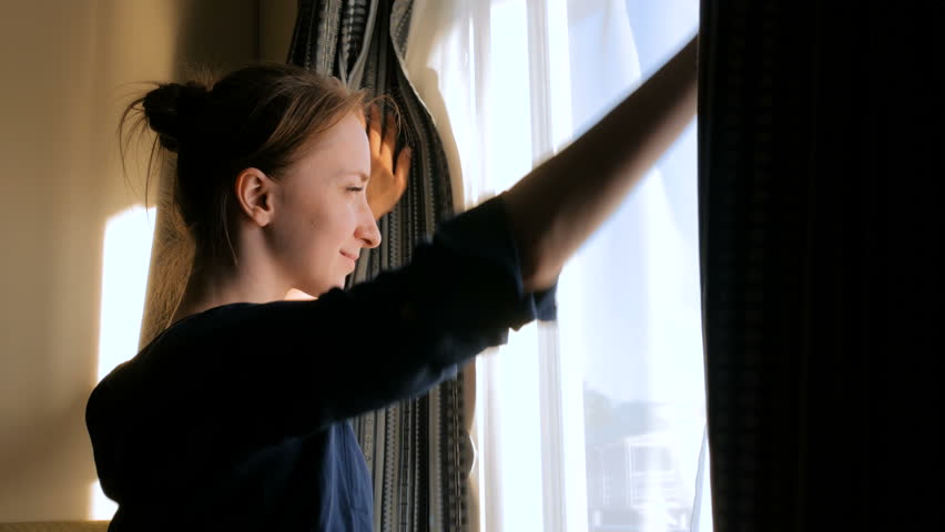 Happy woman opening curtains and looking out of window in cabin of cruise ship at morning Royalty-Free Stock Footage #33550858