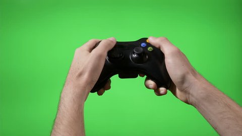 Closeup of gamer hands playing videogame pressing remote controller keys with chroma key background