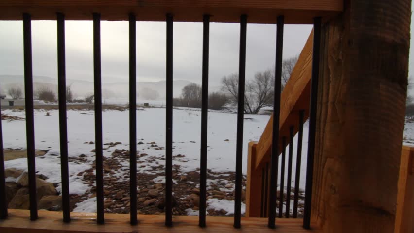 A jib shot of a foggy winter morning from a deck of a house