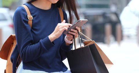 Shopping woman with paper bag and smart phone