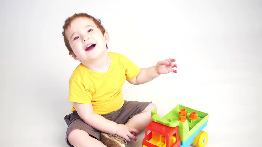 a child playing with a toy truck smiling