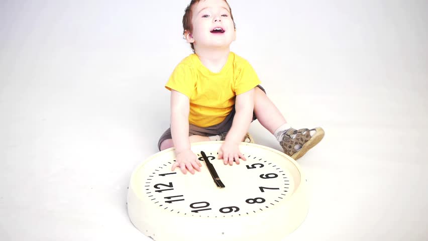 little boy playing with clock