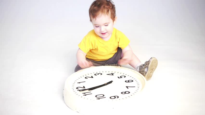 a child playing with a big clock smiling