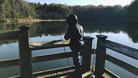 Great slow motion of a kid fishing on a beautiful lake