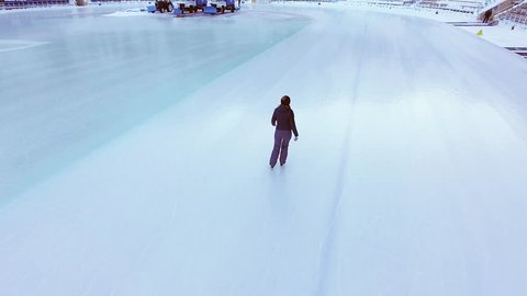 Drone video of young woman ice skating early morning at ice rink outdoor at winter. Ice skate healthy lifestyle footage. Ice-skating Arkivvideo