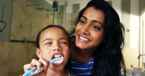 Mother teaching her daughter to brush her teeth in bathroom at home 4k Social distancing and self isolation in quarantine lockdown for Coronavirus Covid19