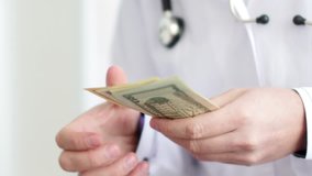 Corrupted doctor counting money and putting it into his pocket. 4K UltraHD video
