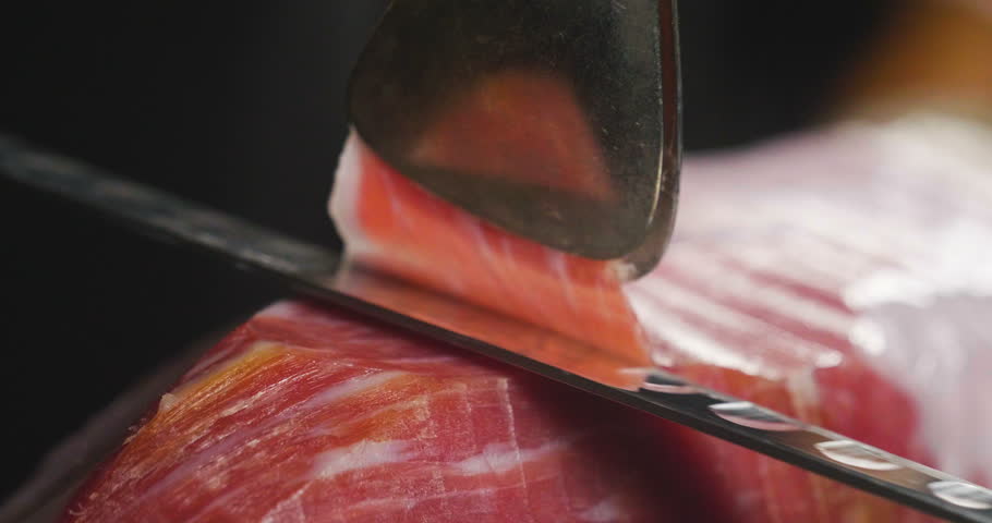 Close up macro of a chef who cuts a slice of ham, of excellent quality, with the knife according to tradition. Concept of: ham, food, Spain and Italy, catering. Royalty-Free Stock Footage #33607915