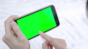 woman take cell phone with green screen on the bed