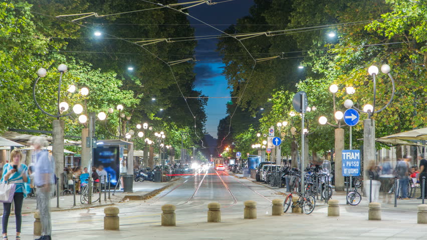 Corso Sempione night timelapse, one of the main radial boulevards of Milan, directed north-west from Arco della Pace, here viewed from Piazza Sempione. Traffic cars and tram. Summer evening after