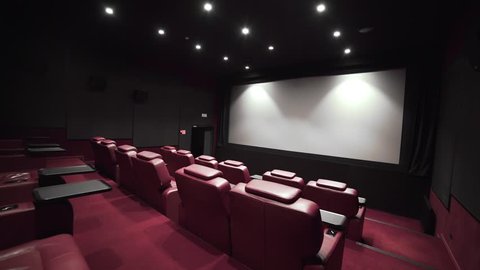 Panorama of the cinema theater with comfort leather armchairs, cinema without people, cinema before the session, vip hall, slow motion