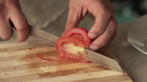 Male hand slicing tomato, super slow motion, shot at 240fps
