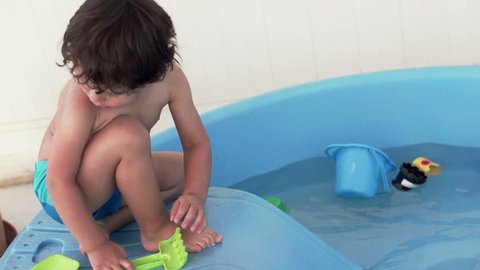 Cute kid playing by plastic pool, super slow motion, shot at 240fps
