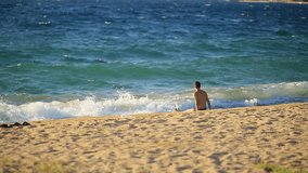 a man enters the water, the Mediterranean, Greece. Travel, summer vacation on the beach.