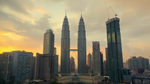 KUALA LUMPUR - CIRCA MAY 2017: Beautiful cloudscape timelapse with zooming in camera motion of the Petronas Twin Towers in sunset time on May 2017 at Kuala Lumpur City Center KLCC